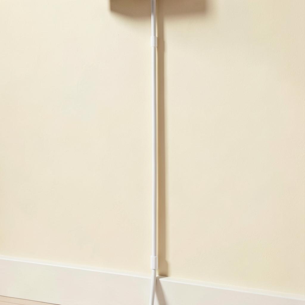 Wall-mounted TV with a slim white cord cover neatly hiding the cables below it
